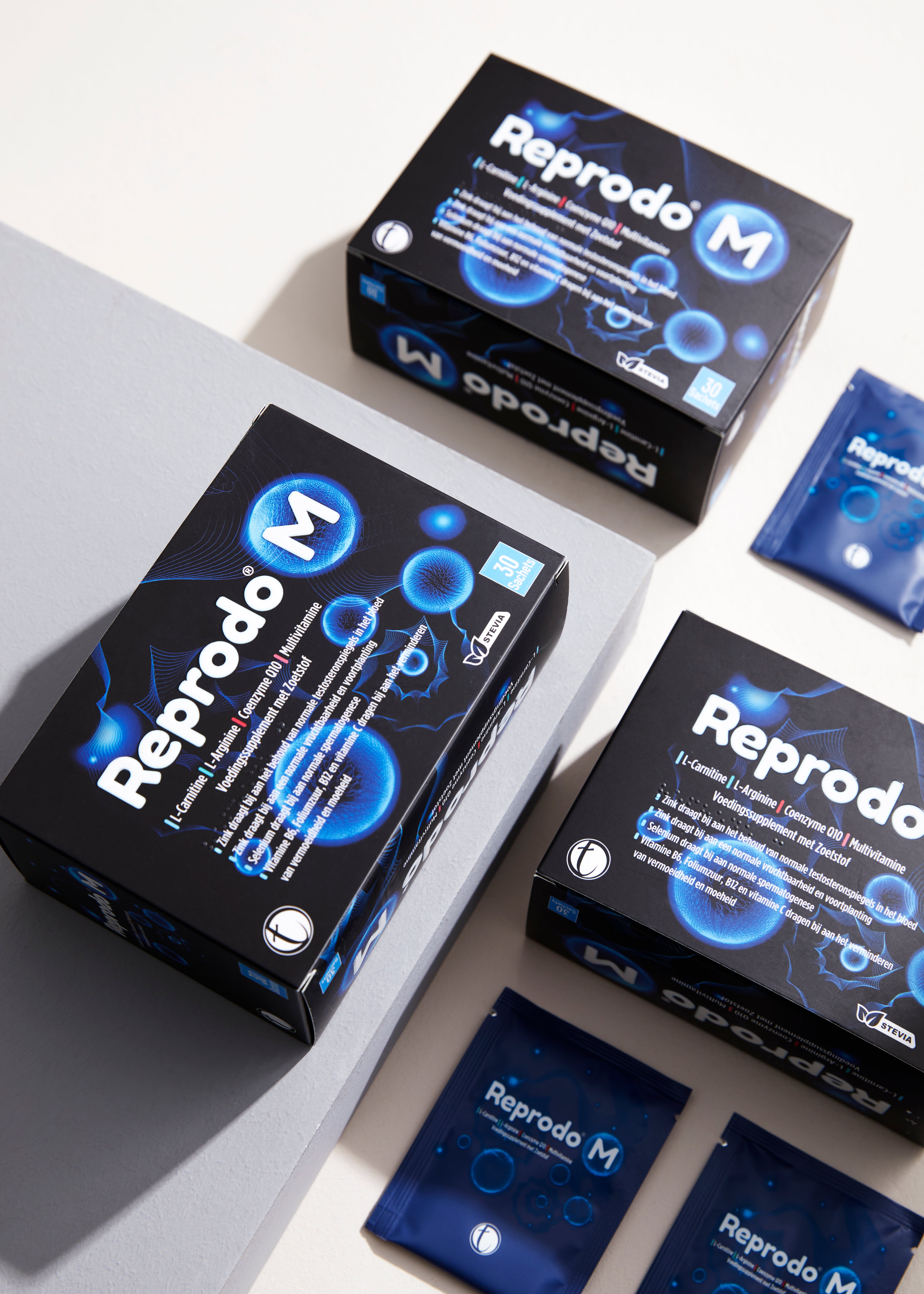 Reprodo M fertility supplement boxes with sachet packets arranged on light background